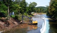 An excavator works on a stream bank