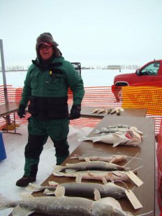 Devils Lake Fire Chief Jim Moe appears next to a few of the seafood caught during last many years fishing tourney.