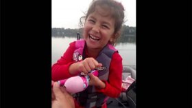 young girl catches huge bass with a Barbie fishing pole